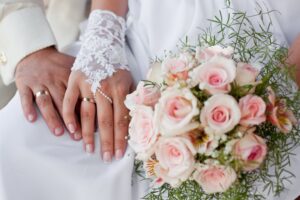 руки новобрачных и букет